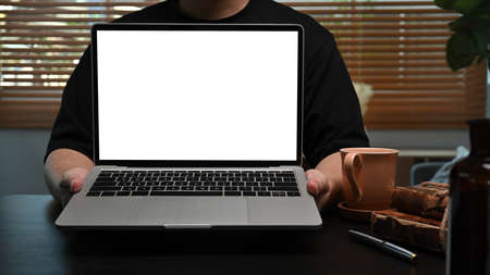 Young man holding mock up computer laptop with blank screen.の写真素材