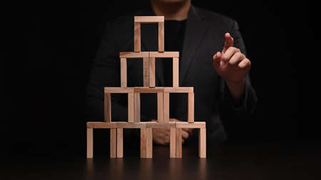 Businessman with wooden block and touching or pointing to something. Business strategy and development concept.の写真素材