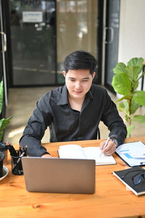 Portrait of handsome businessman working with laptop computer.の写真素材