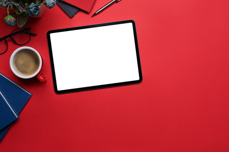 Flat lay digital tablet, coffee cup and books on red background.の写真素材