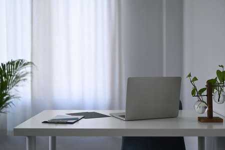 Home office interior.  Mock up computer laptop and houseplant on white table.の写真素材