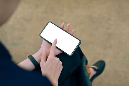 Close up view businesswoman holding smart phone and pointing on empty screen.の写真素材