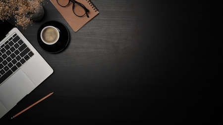 Mock up computer laptop, coffee cup and notebook on black table.の写真素材