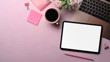 Mock up digital tablet, laptop computer and supplies on pink background.の写真素材
