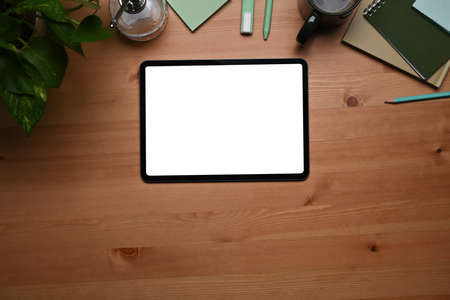 Top view mock up digital tablet, houseplant and coffee cup on wooden table.の写真素材
