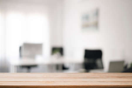 Empty wooden table with blurred modern office background. Copy space for display of product.