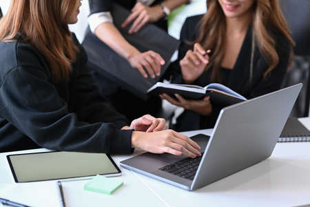 Two young businesswomen reading financial document together at a boardroom.の写真素材