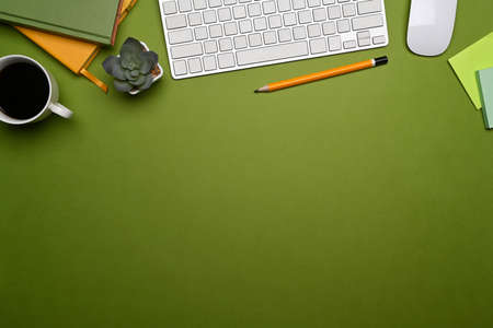 Mockup computer laptop, books, glasses and houseplant on green background.の写真素材