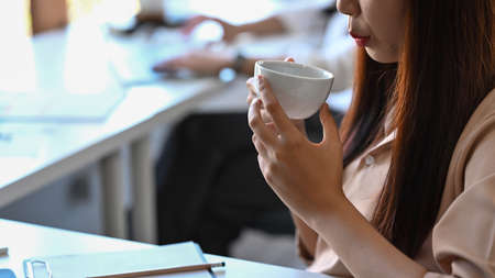 Asian businesswoman sitting in bright modern office and working with laptop computer.の写真素材