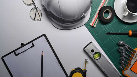 Top view clipboard, coffee cup and architect equipment on white table.の写真素材