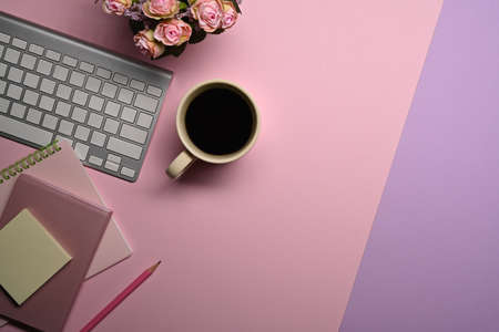 Top view coffee cup, notebook and wireless keyboard on feminine workspace.の写真素材