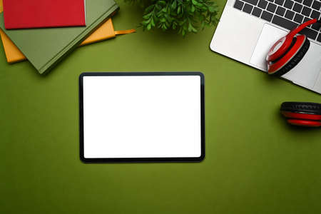Flat lay, mockup digital tablet, headphone, laptop computer and notebook on green background.の写真素材