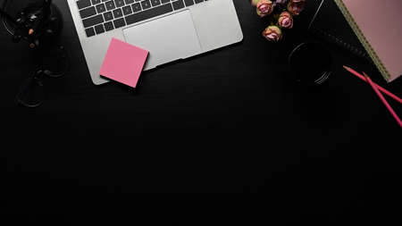 Flat lay, computer laptop, sticky note and coffee cup on black table with copy space.の写真素材