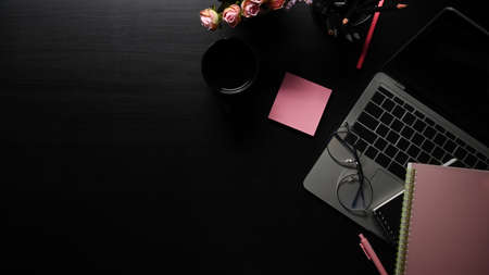 Flat lay, computer laptop, sticky note and coffee cup on black table with copy space.