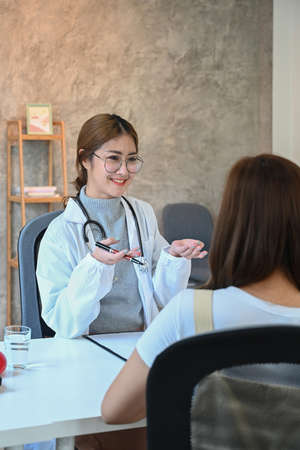 Young female doctor consulting her patient in medical office.の写真素材