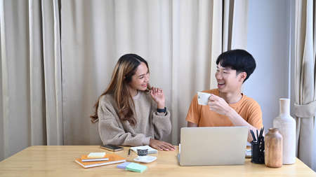 Young couple browsing internet with digital tablet together in living room.の写真素材
