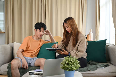 Young couple shopping online or surfing internet on digital tablet together.の写真素材