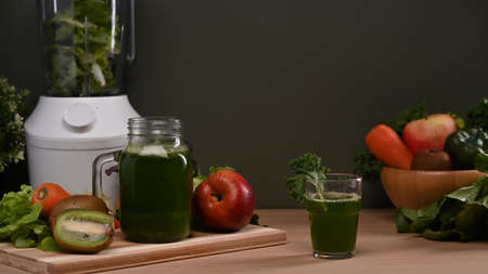Modern blender with fresh vegetables and fruits on wooden table. Healthy food concept.の写真素材