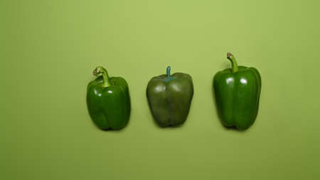 Fresh whole sweet pepper isolated on green background.の写真素材