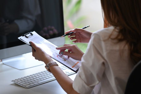 Rear view businesswoman sitting at office desk and working with colleague.の写真素材