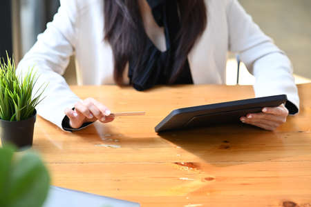 Cropped shot young woman holding digital tablet and credit card.の写真素材