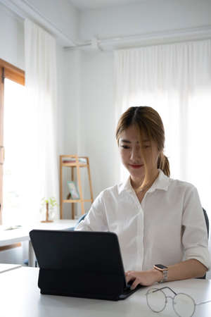 Young female graphic designer working with computer tablet at creative office.の写真素材