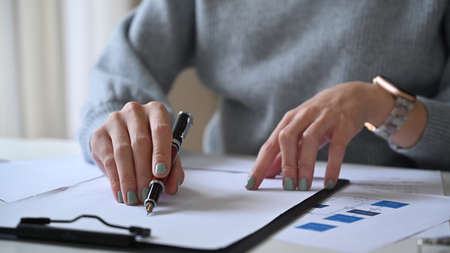 Young businesswoman checking financial graph at her office desk.の写真素材