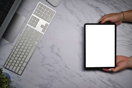 Overhead view woman using digital tablet on marble table.の写真素材