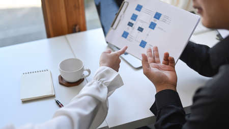 Businessman holding financial documents and explaining information to his colleagues.