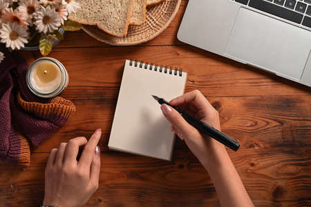 Creative woman holding pen and writing on empty notebook.の写真素材