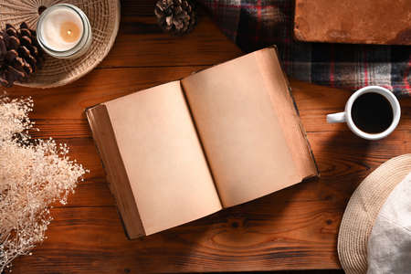 Above view vintage book, cup of coffee, and candle on wooden background.の写真素材