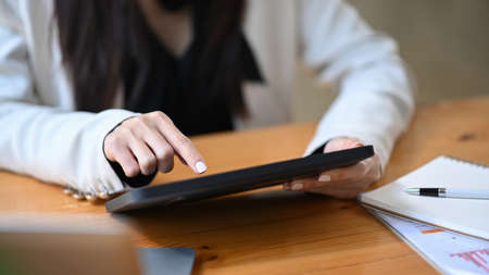 Cropped shot business woman checking news on digital tablet.の写真素材