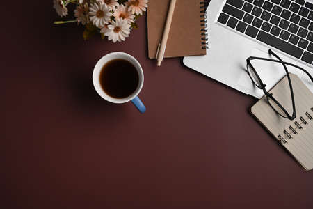 Stylish workplace with laptop computer, notebook, glasses and coffee cup on purple background.の写真素材