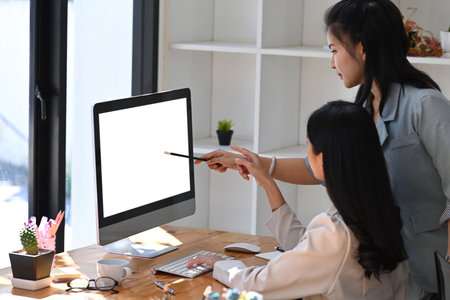 Two business women sharing ideas or startup business plan together.