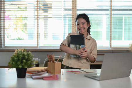 Portrait of young little asian girl holding book and smiling to camera. Back to school concept.の写真素材