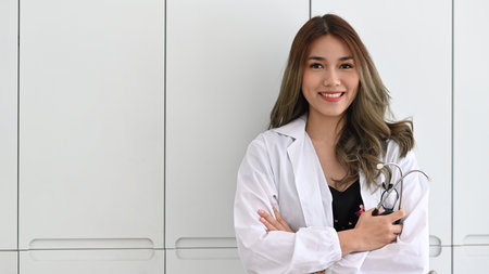 Smiling female doctor using digital tablet in bright modern hospital.の写真素材