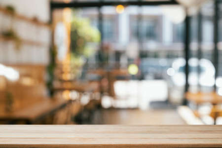 Empty wooden table in front of blurred background of coffee shop. Copy space for display or montage your products.の写真素材
