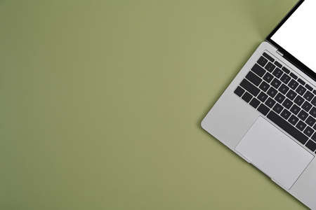 Computer laptop with white screen on green background. Top view.の写真素材