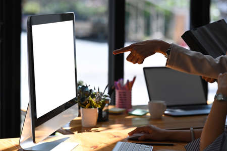 Cropped shot businesspeople pointing on computer screen during discussing project together.の写真素材
