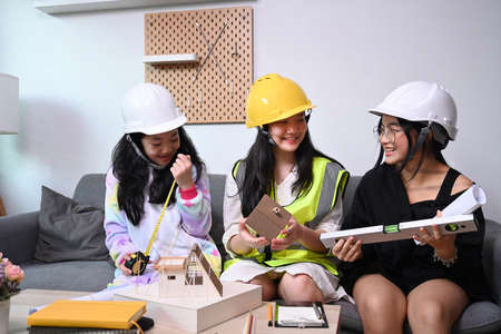 Three asian girls in safety helmet pretend to be engineer.の写真素材