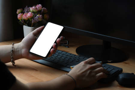 Young man freelancer working with computer and using smart phone at home office.の写真素材