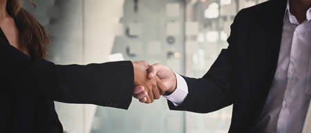 Businesspeople shaking hands after investment deal, finishing up a meeting. Teamwork and partnership concept.の写真素材