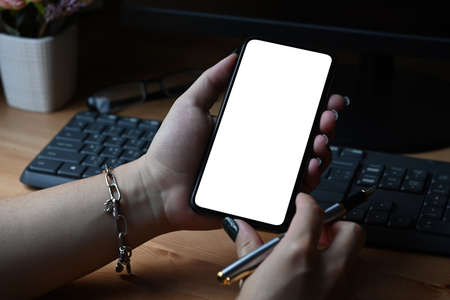 Close up view woman holding smartphone with blank display for graphics display montage.