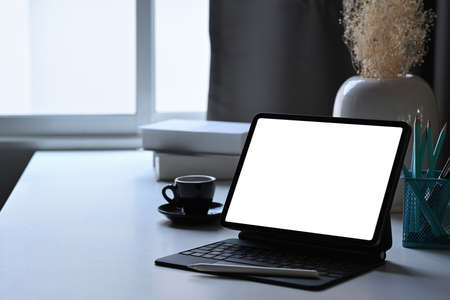 Laptop computer, coffee cup and supplies on white table. Home office workplace concept.の写真素材