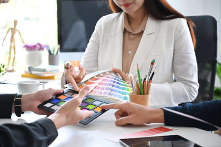 Team of creative designers working on new project together in a design studio.