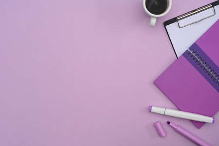 Top view notebook, clipboard and coffee cup on purple background with copy space.の写真素材