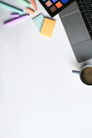 Creative workplace with laptop computer, sticky notes, coffee cup and color swatches on white table. Copy space.の写真素材