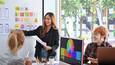 Website development team brainstorming and discussing about mobile app interface wireframe design at...