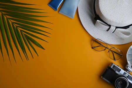 Beach summer accessories with sunglasses, sunscreen bottles in beg on yellow background. Summer vacation concept.の写真素材