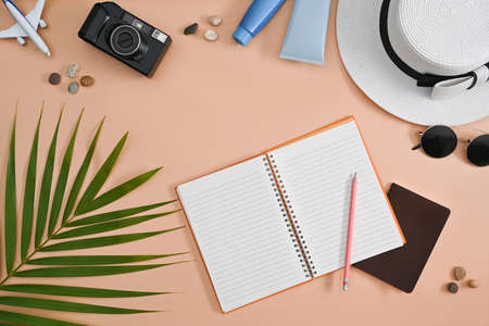Traveler accessories with passport, sunglasses, camera and hat on beige background. Travel, summer and holiday concept.の写真素材